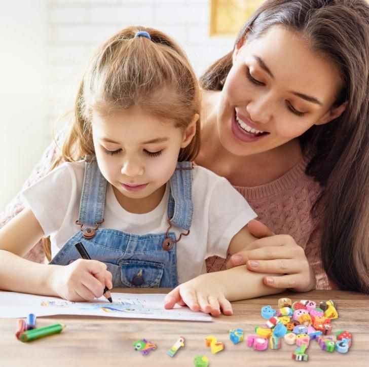 A woman and a young girl sit at a table drawing with colored pencils and erasers shaped like animals.