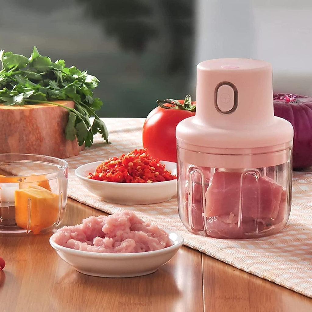 A Portable USB Rechargeable Electric Chopper, featuring a compact design with a transparent container, stainless steel blades, and a USB charging port. Ideal for chopping vegetables, fruits, and nuts, this chopper offers one touch operation and easy cleaning.