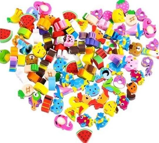 A pile of colorful, assorted cartoon-themed erasers shaped like animals, food, and various objects arranged on a white background.