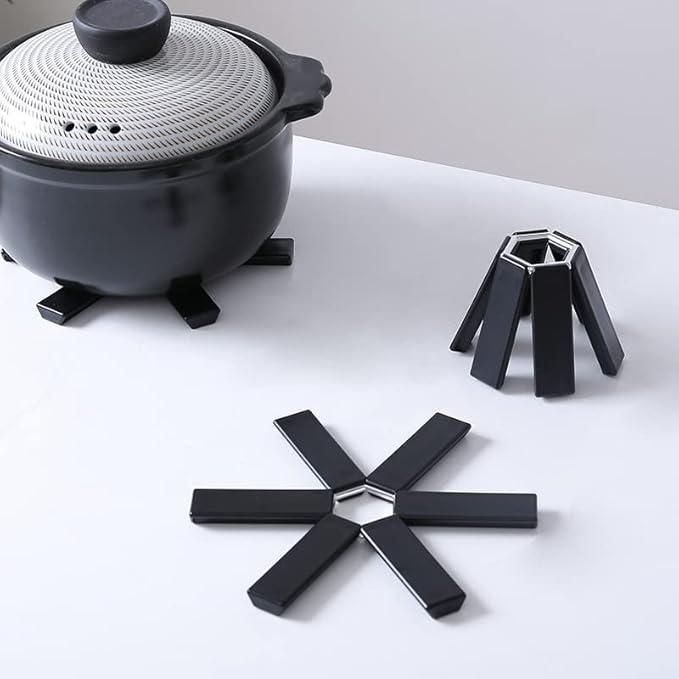 "Flower-shaped black plastic heat pad for hot pots and pans protection"






