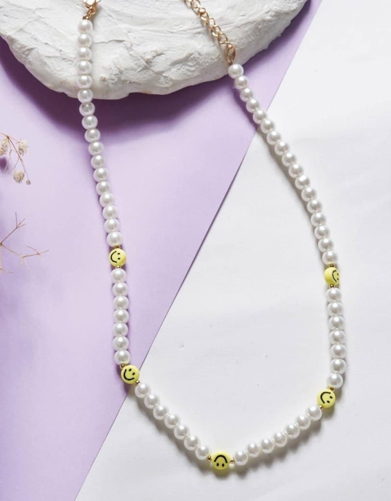 PD Enterprise White Pearl & Yellow Smiley Face Necklace featuring a playful combination of lustrous white pearls and cheerful yellow smiley face beads. The necklace measures 18 inches in length and is secured with a lobster clasp, offering a unique and fun accessory perfect for casual wear and special occasions.