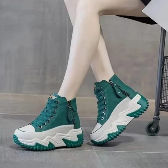 Person wearing teal high-top sneakers with thick white zigzag soles.