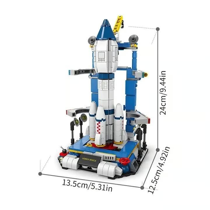 A toy rocket launch vehicle with blue and white colors, shown with dimensions of 24 cm in height, 13.5 cm in width, and 12.5 cm in depth.