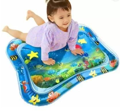 A young child in a purple outfit playing on a blue water play mat decorated with aquatic animals and sea creatures.
