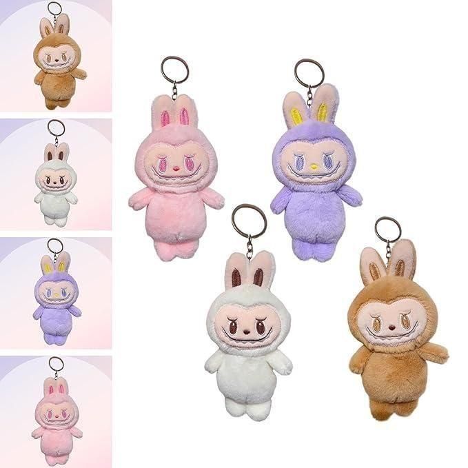 A set of five plush keychains shaped like cute cartoon rabbits in brown, white, pink, and purple, each with a round face and bunny ears.