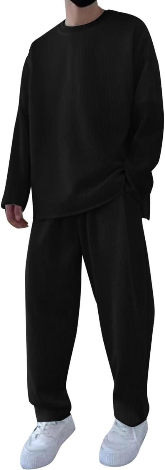 A person wearing a loose-fitting black outfit with long sleeves and matching pants, paired with white sneakers.