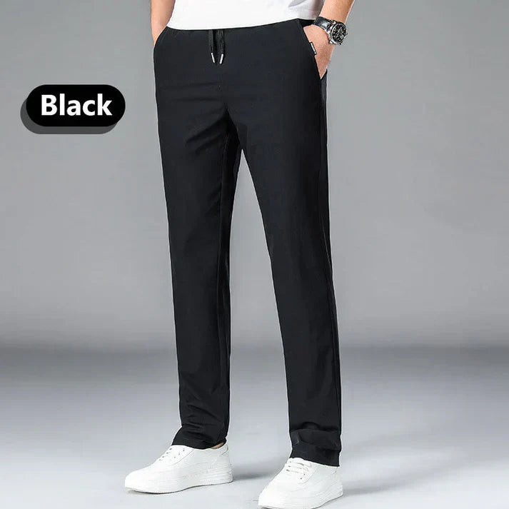 A person wearing black casual pants, a white shirt, and white sneakers, with hands in pockets. The word 'Black' is displayed on the left.