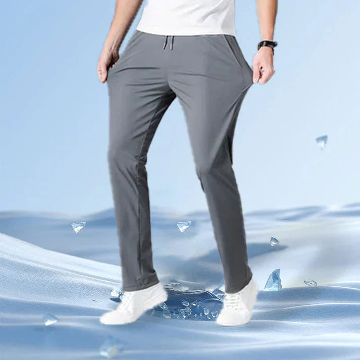 A person wearing gray jogger pants and white sneakers, standing on a wavy blue surface with ice crystal effects.