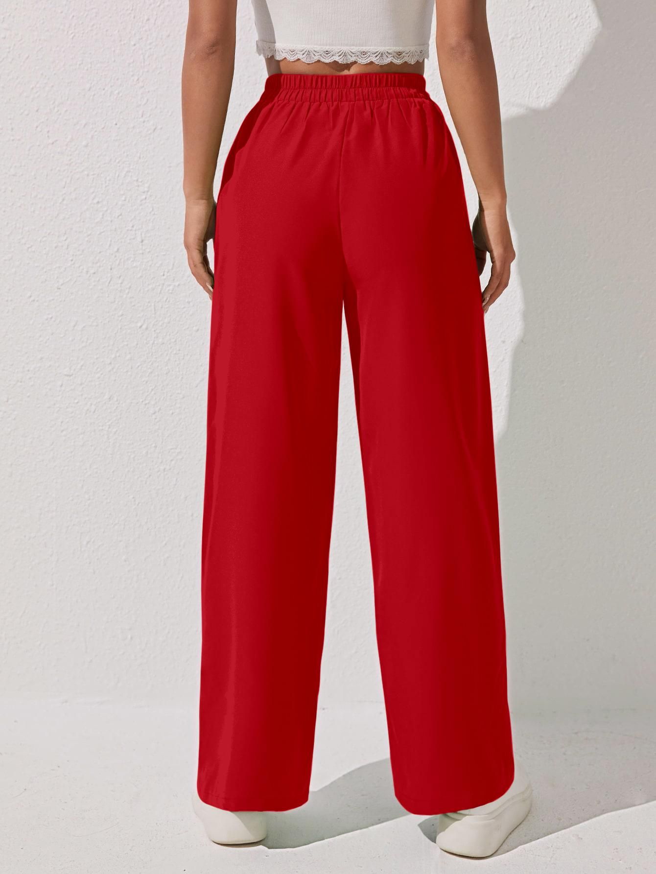 A person wearing high-waisted red wide-leg pants and a white cropped top, shown from the back.